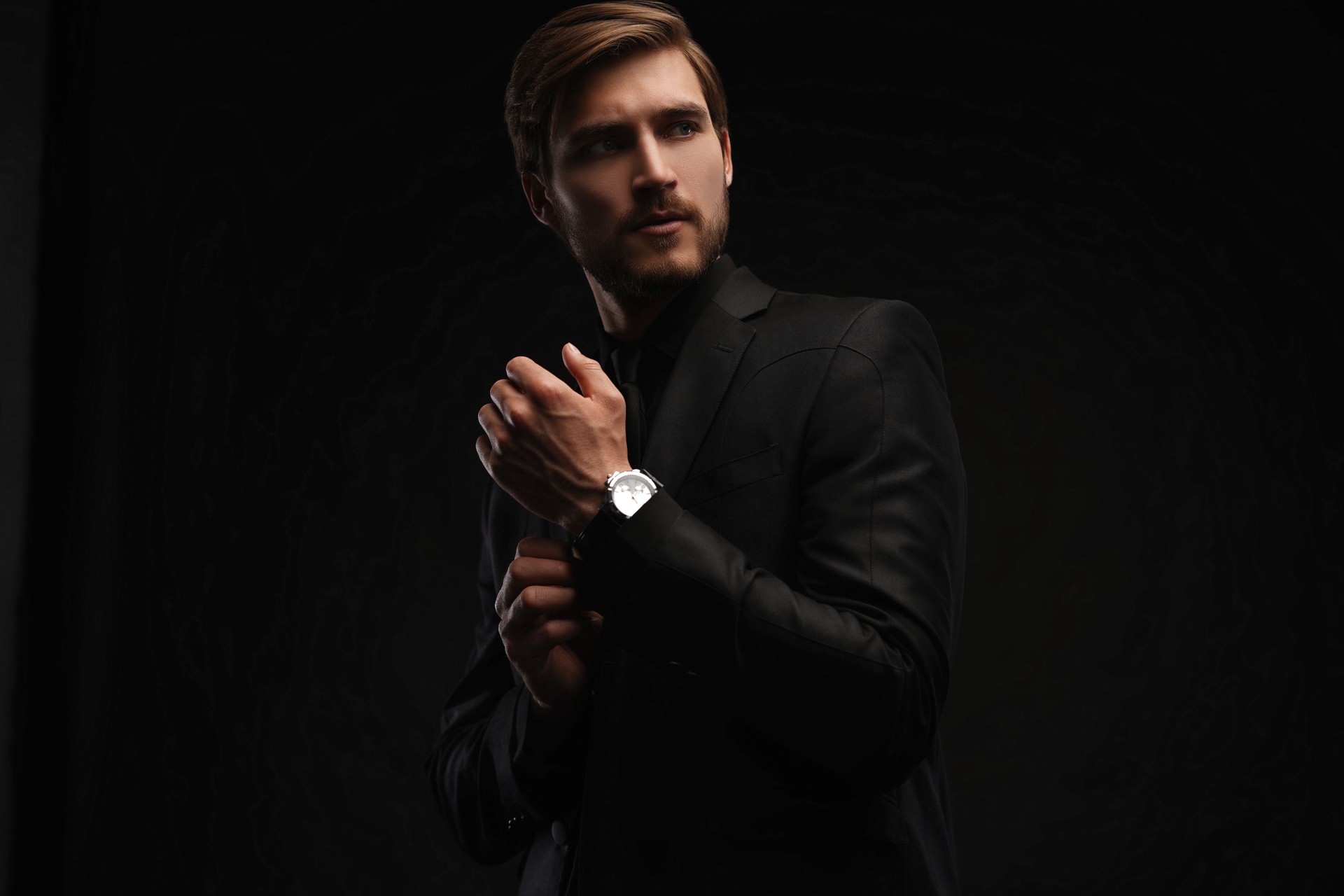 Elegant young handsome man in black suit. Studio fashion portrait
